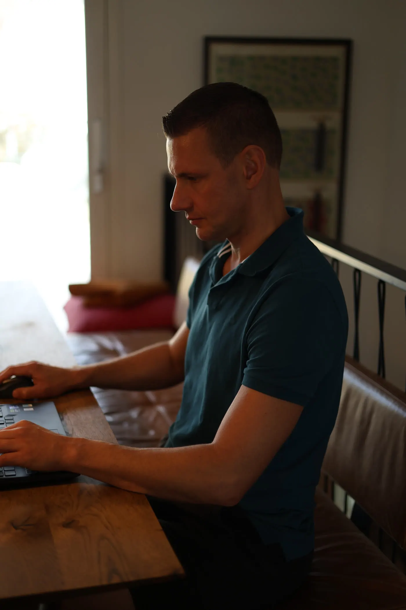 Matthias schreibt entspannt am Laptop am Fenster