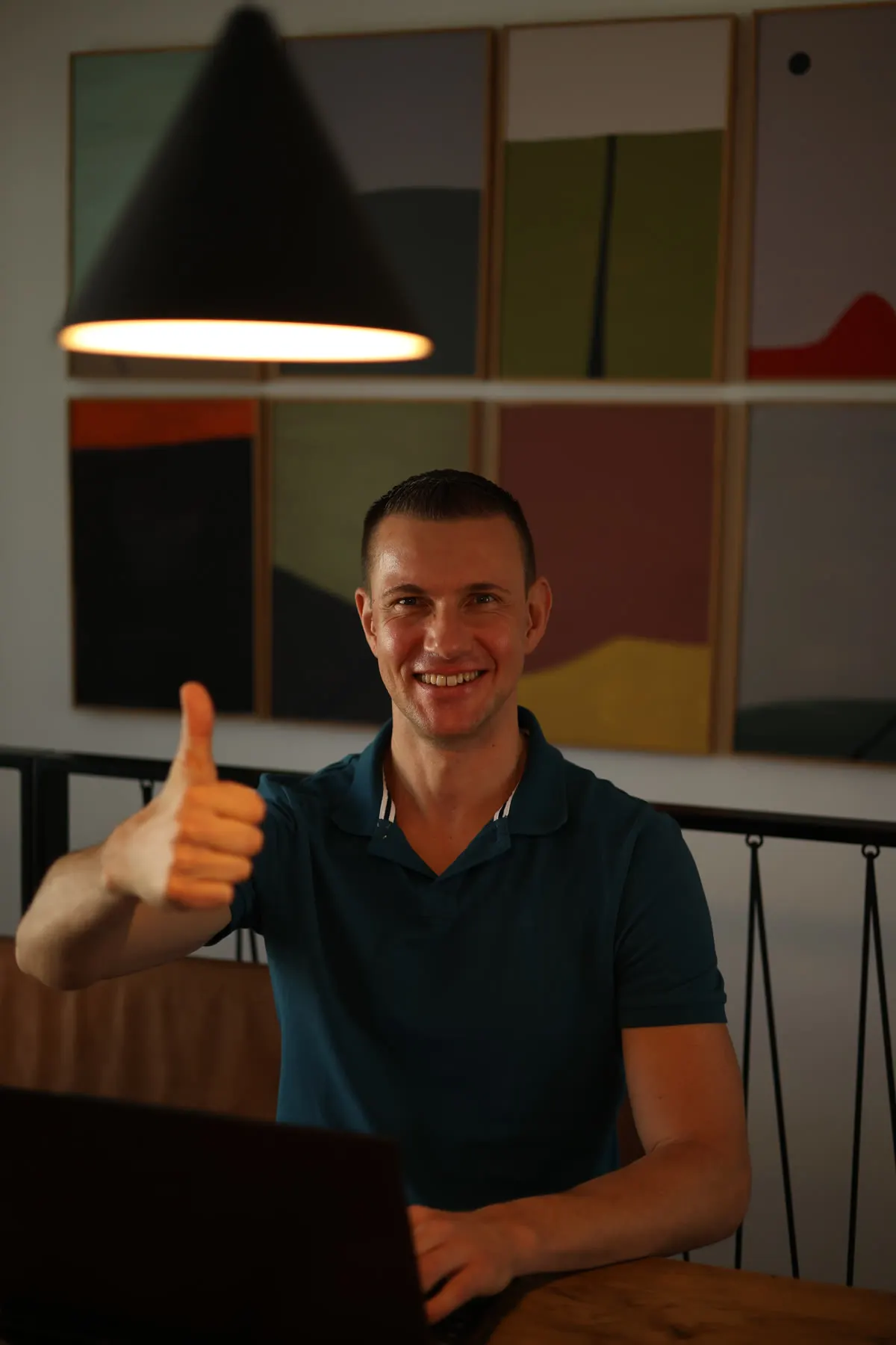 Matthias Neumann am Laptop, lächelnd mit Daumen hoch